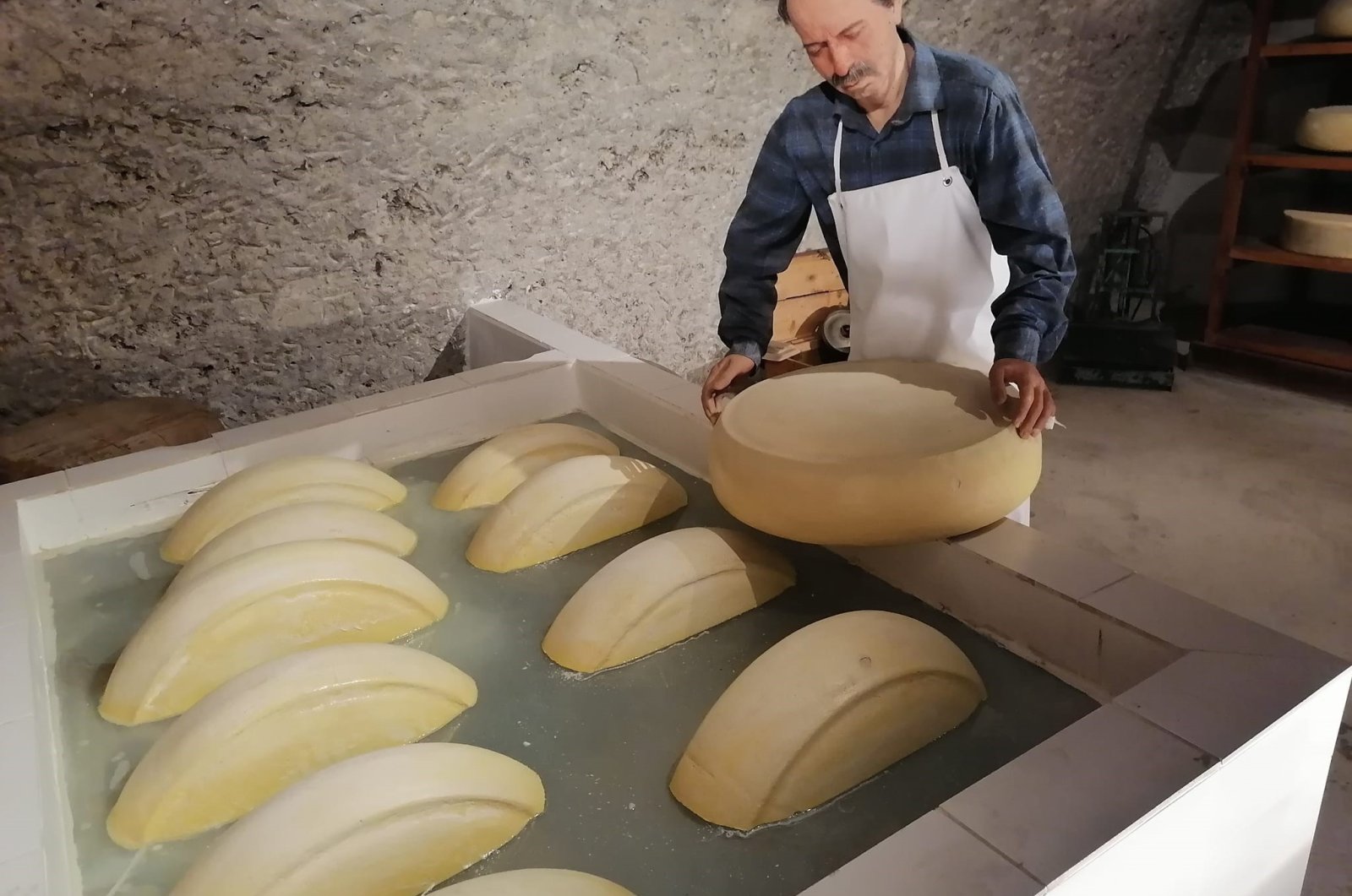 One of the sculptures in the Kars Cheese Museum depicts a man making cheese, Kars, Türkiye, Aug. 19, 2024. (IHA Photo)