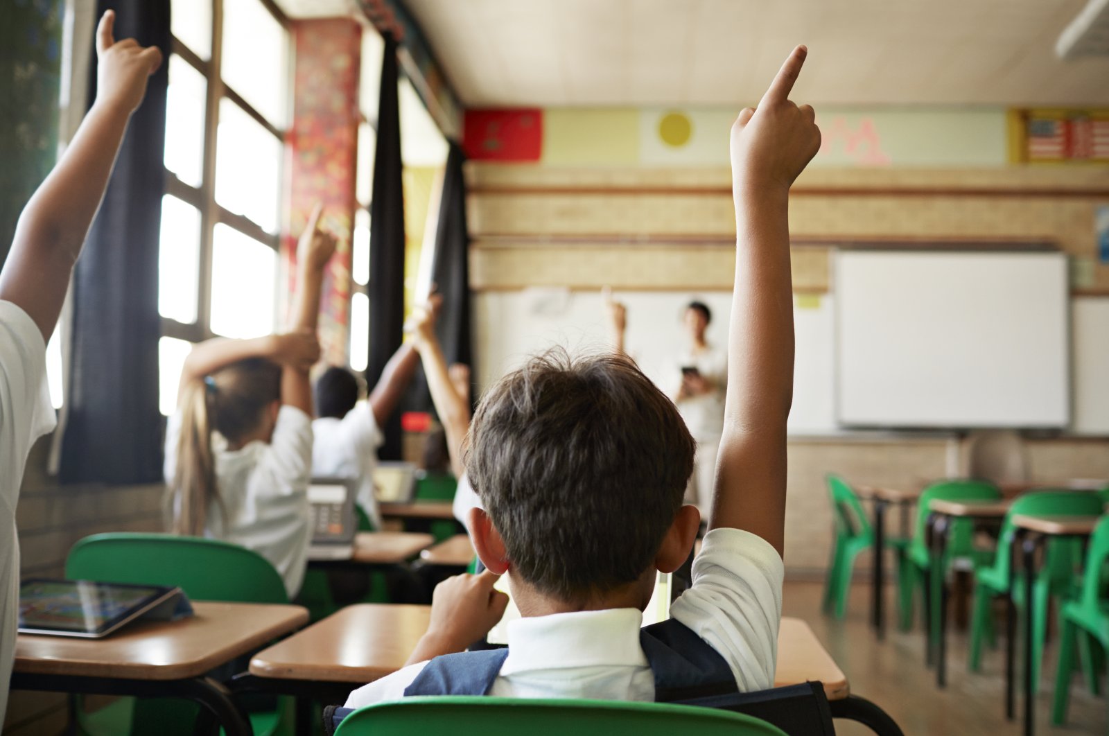 Students raise their hands to speak during class. (Getty Images)