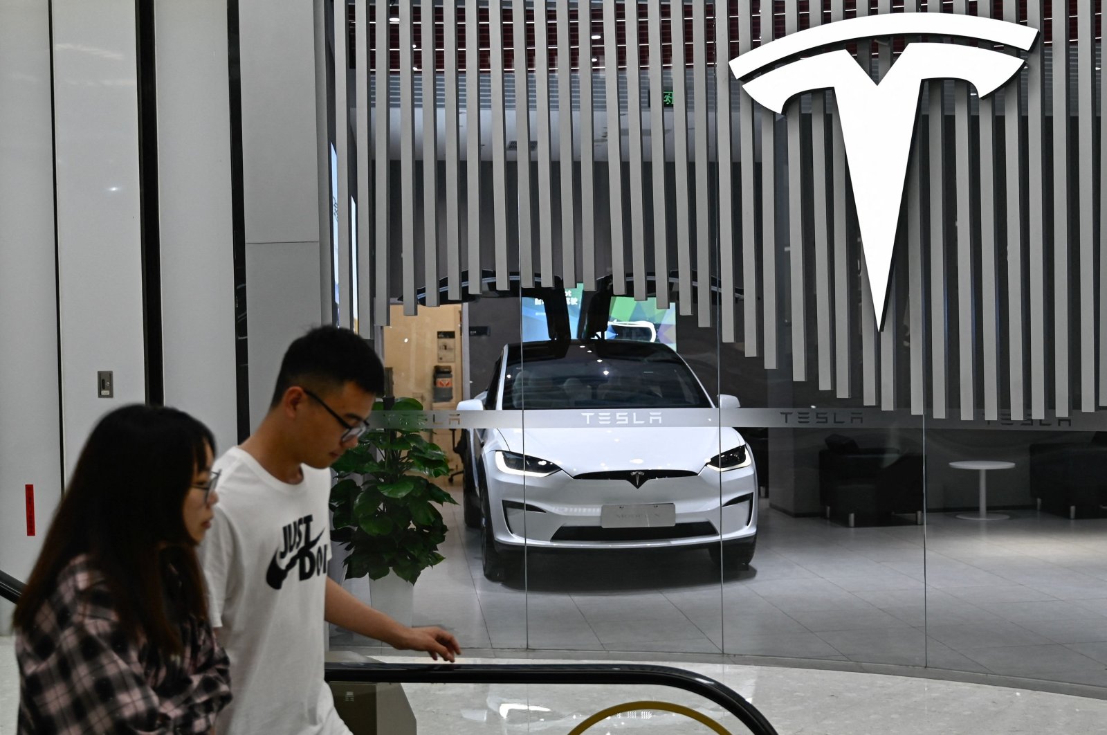 People walk past a Tesla shop at a shopping mall in Beijing, China, July 9, 2024. (AFP Photo)