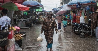 A woman walks down a street market as rain falls in Mawlamyaing in Myanmar’s Mon state, July 16, 2024. (AFP Photo)