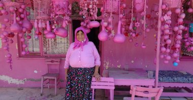 Sakine Akkul, 75, waiting in front of her pink house in Sav, Isparta, Türkiye, Aug. 21, 2024. (IHA Photo)