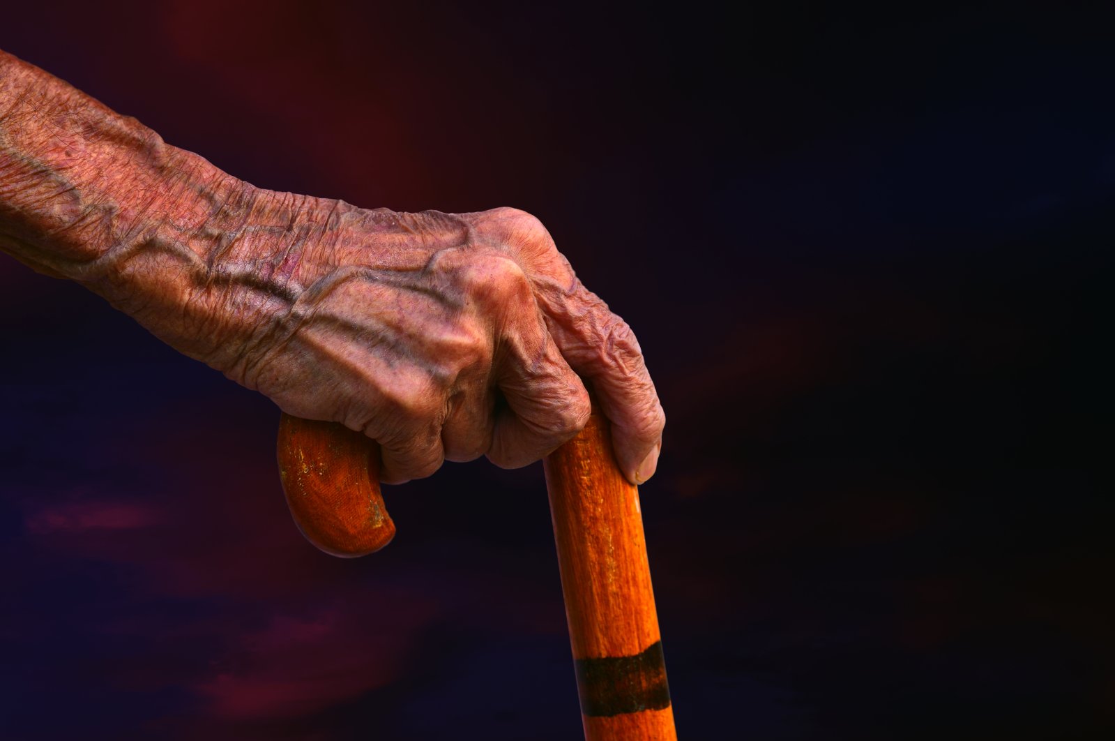 An elderly person holds a walking stick. (Getty Images)