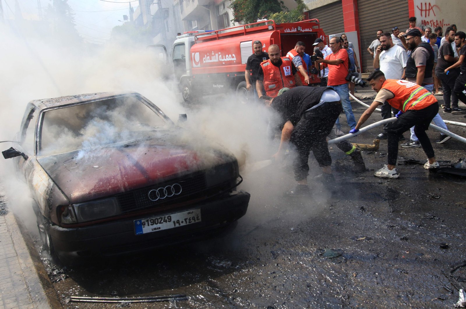 Lebanese firefighters put out a fire in a car after an Israeli strike in the southern city of Sidon, Lebanon, Aug. 21, 2024. (AFP Photo)