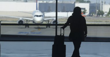 A holiday traveler looks out at a airplane at Salt Lake City International Airport, Salt Lake City, Utah, U.S., July 3, 2024. (AP Photo)