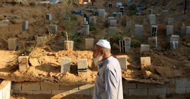 Palestinian grave digger Saadi Hassan Barakeh, 63, walks past breeze blocks used to mark graves at the Deir al-Balah cemetery, Gaza Strip, Palestine, Nov. 10, 2023. (AFP Photo)