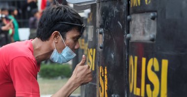 A protester gestures to a riot police officer, as people protest outside the Indonesian Parliament against the revisions to the country's election law, which analysts believe goes through a rushed process of legislation and is designed to block a popular candidate from running as the capital's governor, Jakarta, Indonesia, Aug. 22, 2024. (Reuters Photo)