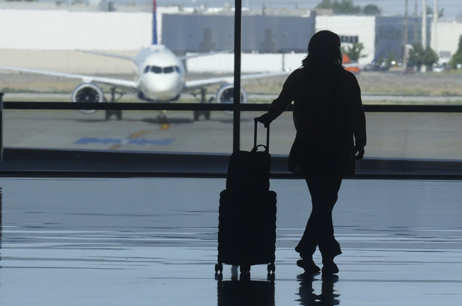 A holiday traveler looks out at a airplane at Salt Lake City International Airport, Salt Lake City, Utah, U.S., July 3, 2024. (AP Photo)