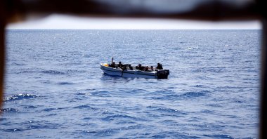 A migrant gestures to Open Arms NGO rescue boat &quot;Astral&quot; (not pictured) from a fibreglass boat in international waters south of Lampedusa, in the central Mediterranean Sea, Aug. 9, 2024. (Reuters Photo)