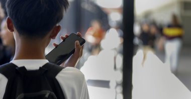 A student uses their cell phone after unlocking the pouch that secures it from use during the school day at Bayside Academy, San Mateo, California, U.S., Aug. 16, 2024. (AP Photo)
