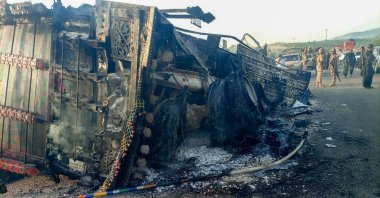 Security personnel stand guard near the charred vehicle at the shooting site on the national highway in the Musakhail district, Balochistan, Pakistan, Aug. 26, 2024. (AFP Photo)