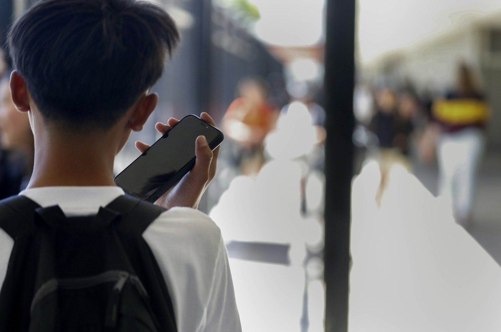 A student uses their cell phone after unlocking the pouch that secures it from use during the school day at Bayside Academy, San Mateo, California, U.S., Aug. 16, 2024. (AP Photo)