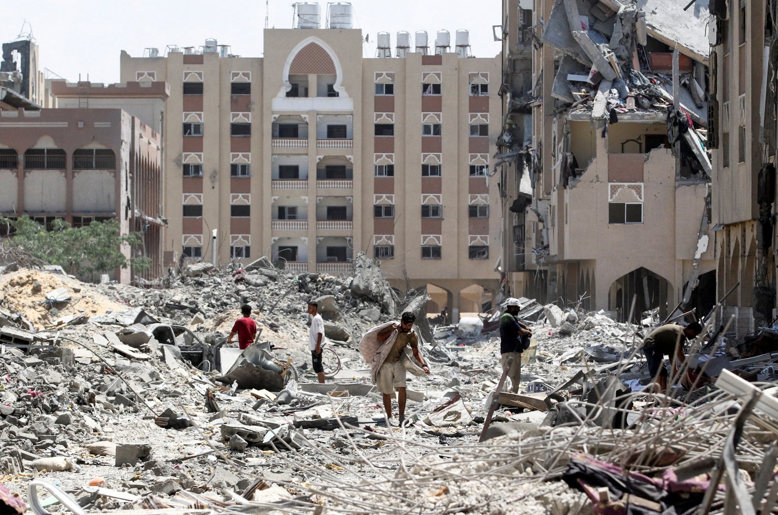 Palestinians inspect damage in Qatari-funded Hamad City, following an Israeli raid, in Khan Younis, in the southern Gaza Strip, Aug. 24, 2024. (Reuters Photo)