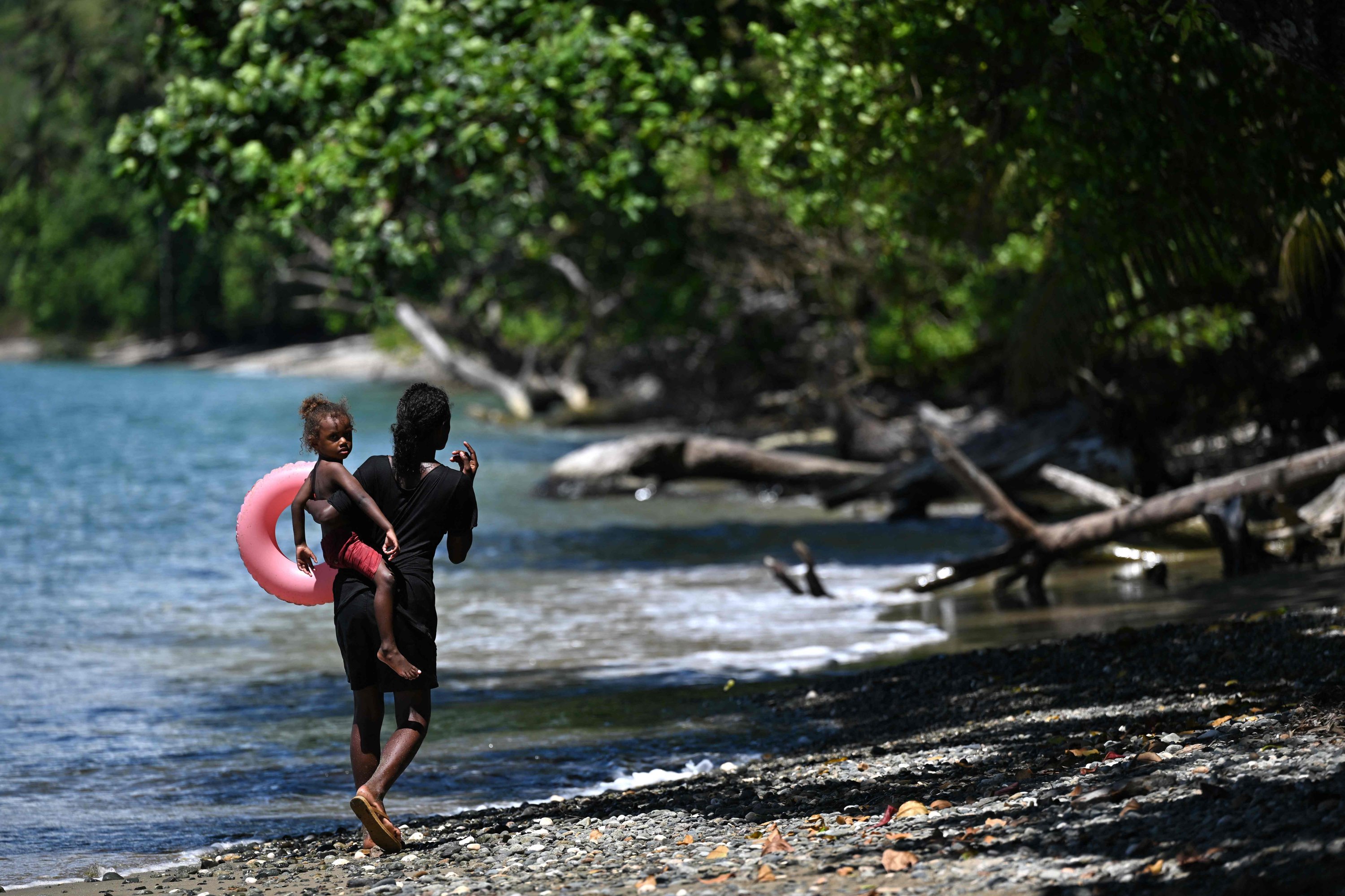 A woman and child walking along the shore in Honiara, the capital city of the Solomon Islands, April 19, 2024. (AFP Photo)