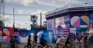 Cyclists ride past the Place de la Concorde Paralympic site covered in "Paris 2024" tarpaulins ahead of the Paris 2024 Paralympic Games, Paris, France, Aug. 21, 2024. (AFP Photo)