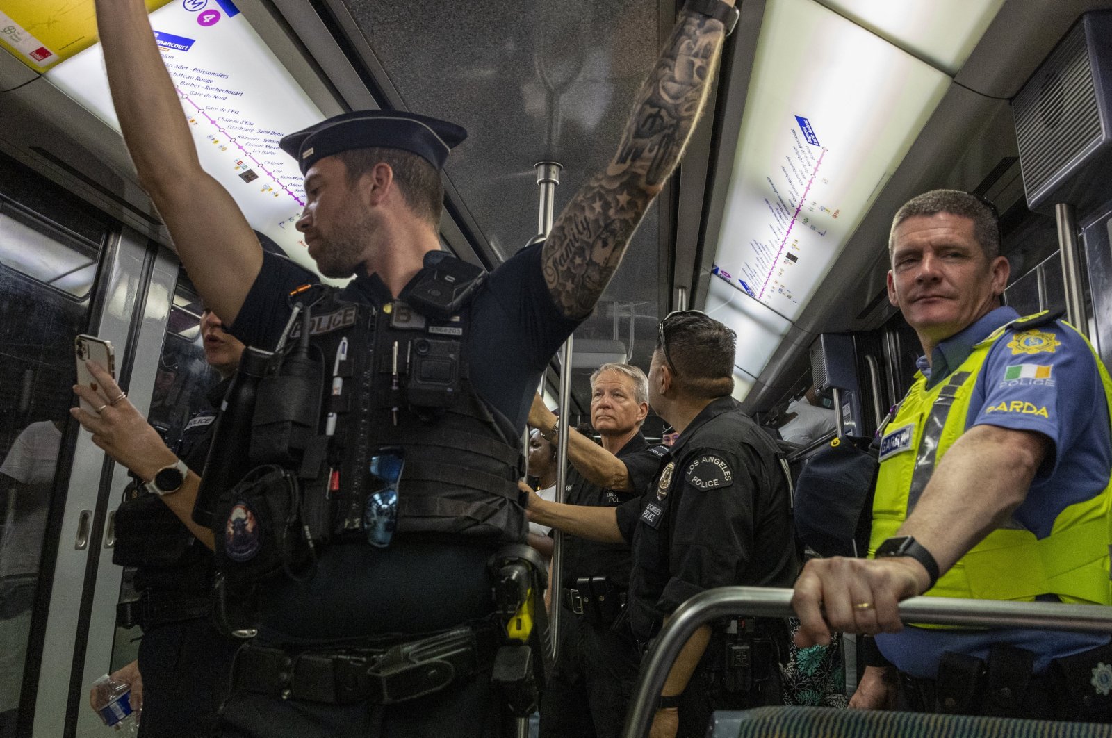 A French police officer (L), two U.S. Los Angeles officers (C) and an Irish police officer (R) keep watch during a patrol mission in the metro, during the Paris Olympic Games, Paris, France, Aug. 8, 2024. (EPA Photo)