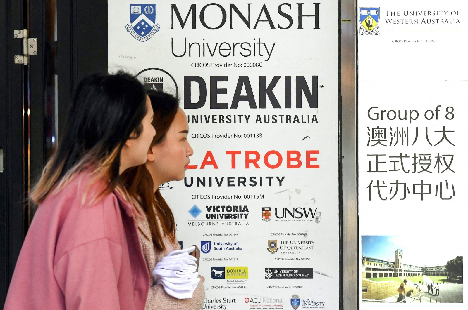 Women walk past signage advertising Australian universities, in Melbourne, Australia, Aug. 27, 2024. (AFP Photo)