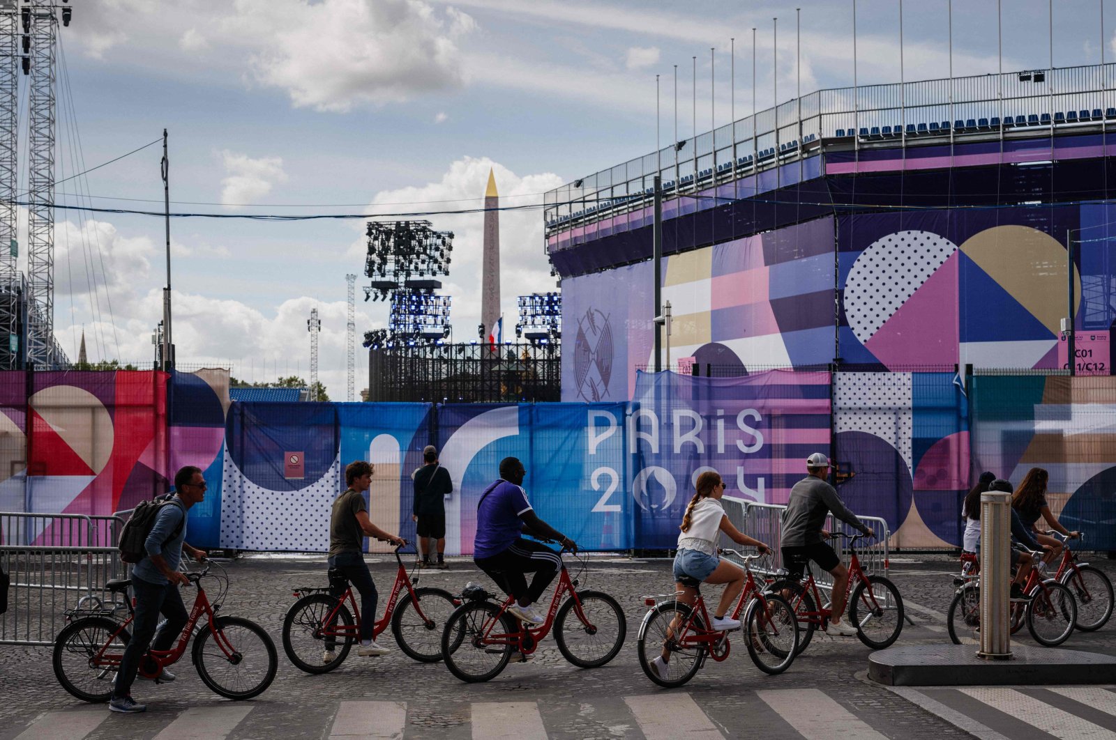 Cyclists ride past the Place de la Concorde Paralympic site covered in &quot;Paris 2024&quot; tarpaulins ahead of the Paris 2024 Paralympic Games, Paris, France, Aug. 21, 2024. (AFP Photo)