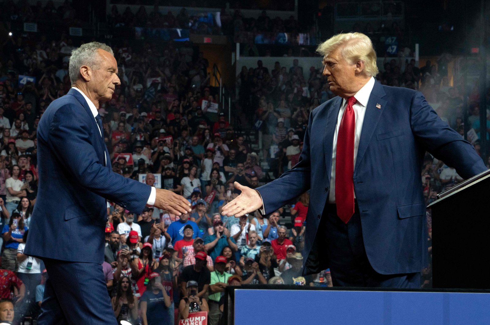 Former Republican presidential candidate Robert F. Kennedy Jr. and Republican presidential nominee, former U.S. President Donald Trump shake hands during a campaign rally at Desert Diamond Arena, Aug. 23, 2024. (AFP Photo)