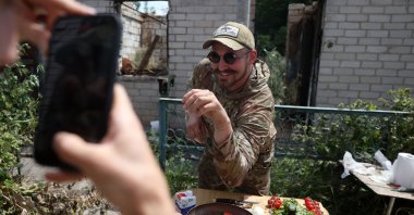 Ukrainian serviceman and influencer Ruslan Mokrytskyi poses for the camera as he cooks pasta in the Donetsk region, Ukraine, July 27, 2024. (AFP Photo)