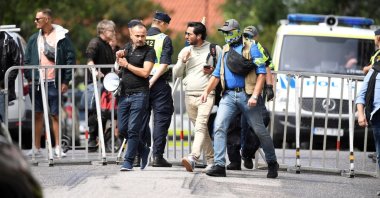 Salwan Momika (C), who planned to burn a copy of the Quran, the Muslim holy book, is escorted by police in Stockholm, Sweden, July 20, 2023. (Reuters Photo)