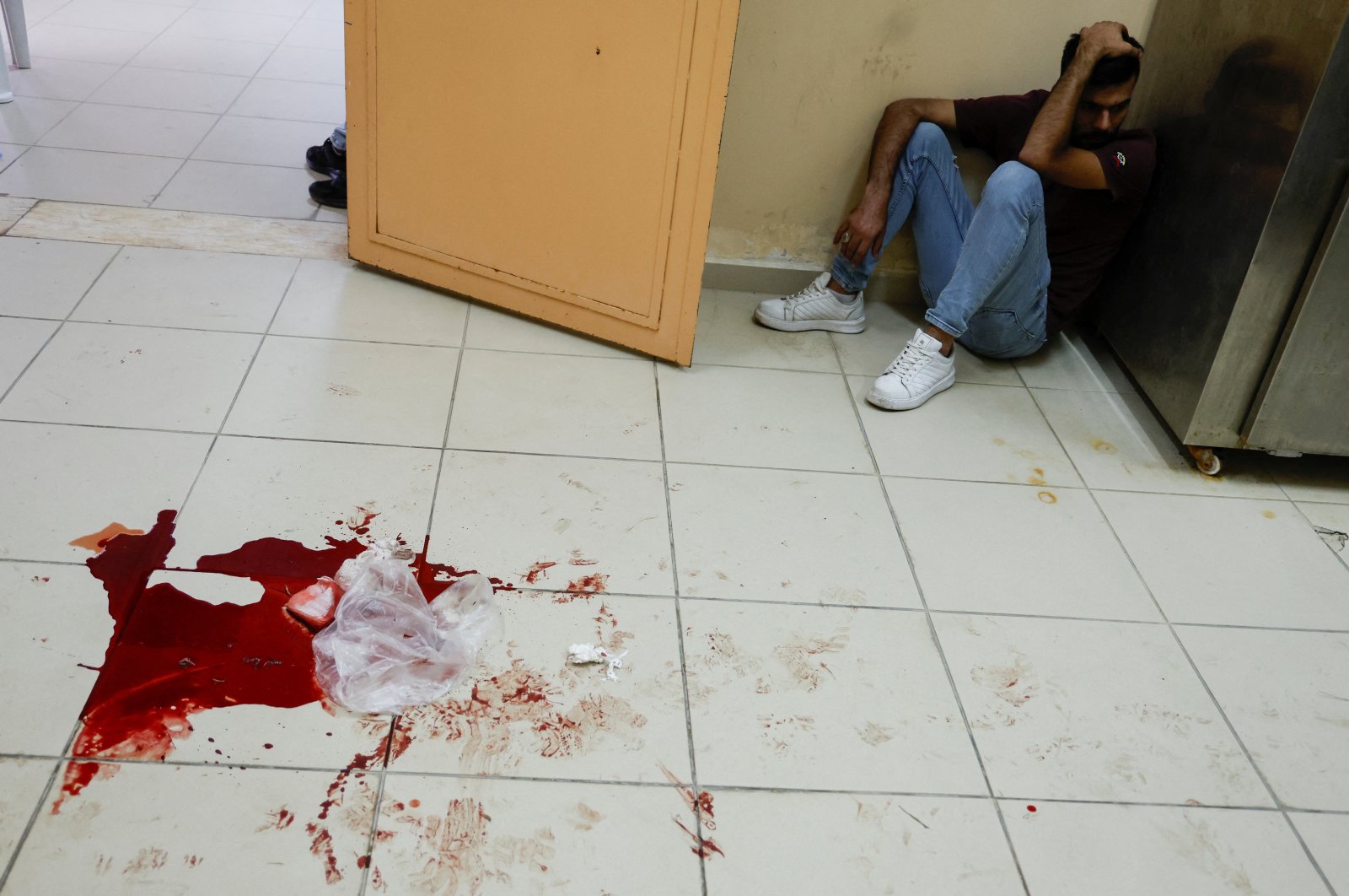 A Palestinian man sits next to blood splattered on the floor at a morgue in Tubas, in the Israeli-occupied West Bank, Palestine, Aug. 28, 2024. (Reuters Photo)