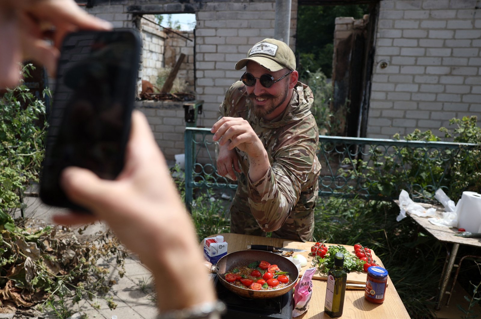 Ukrainian serviceman and influencer Ruslan Mokrytskyi poses for the camera as he cooks pasta in the Donetsk region, Ukraine, July 27, 2024. (AFP Photo)