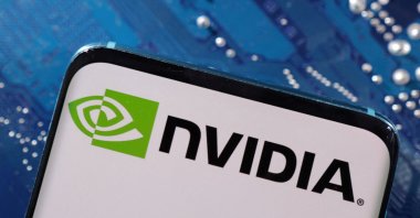 A smartphone with a displayed Nvidia logo is placed on a computer motherboard in this illustration taken on March 6, 2023. (Reuters Photo)