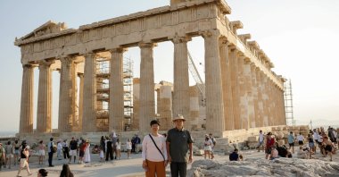 Tourists pose for a photo in front of the Parthenon temple atop the Acropolis hill, Athens, Greece, Aug. 6, 2024. (Reuters Photo)