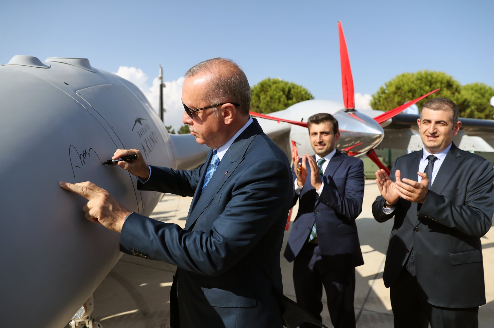 Selçuk (C) and Haluk Bayraktar (R) watch as President Recep Tayyip Erdoğan signs a Bayraktar Akıncı combat drone in Çorlu, northwestern Tekirdağ province, Aug. 29, 2021. (AA Photo)