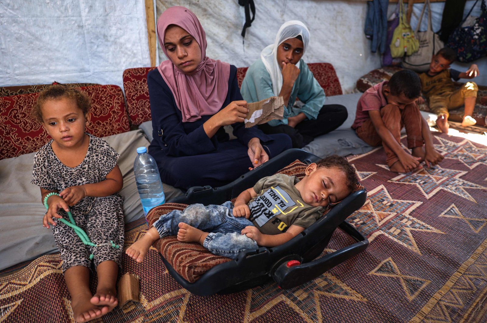 Palestinian boy Abdel Rahman Abu al-Jedian who contracted polio a month ago sleeps surrounded by family members in their displacement tent in Deir al-Balah in the central Gaza Strip, Aug. 27, 2024. (AFP Photo)