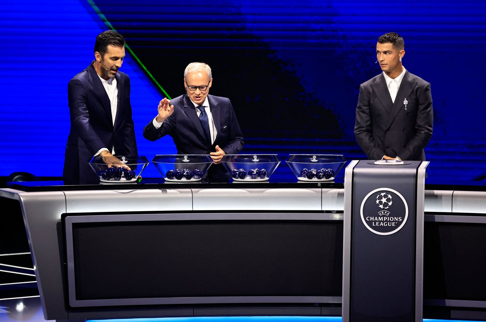 (L-R) Italy’s former goalkeeper Gianluigi Buffon, UEFA Deputy Secretary-General Giorgio Marchetti and Al-Nassr’s forward Cristiano Ronaldo during the ceremony of the draw for the group stage of the UEFA Champions League, Monaco, Aug. 29, 2024.