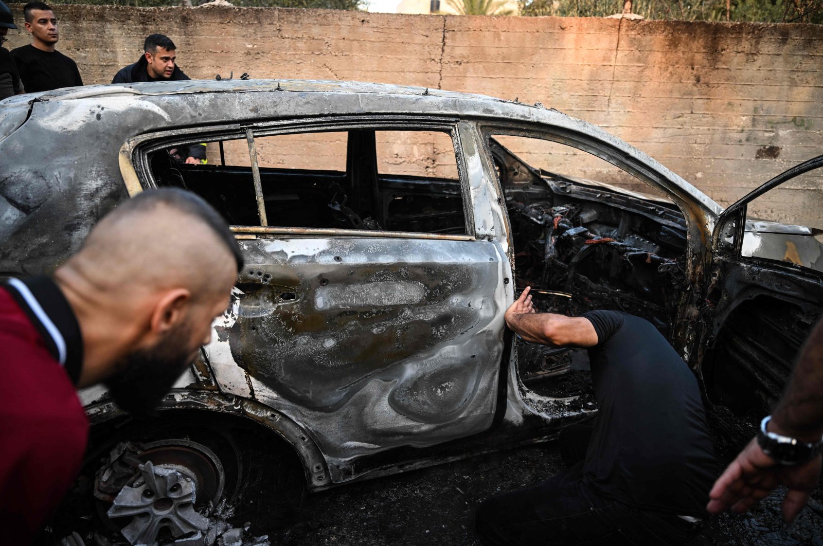 People check a burnt car in the small town of Zababdeh following an Israeli army raid, southeast of Jenin in the occupied West Bank, Palestine, Aug. 30, 2024. (AFP Photo)