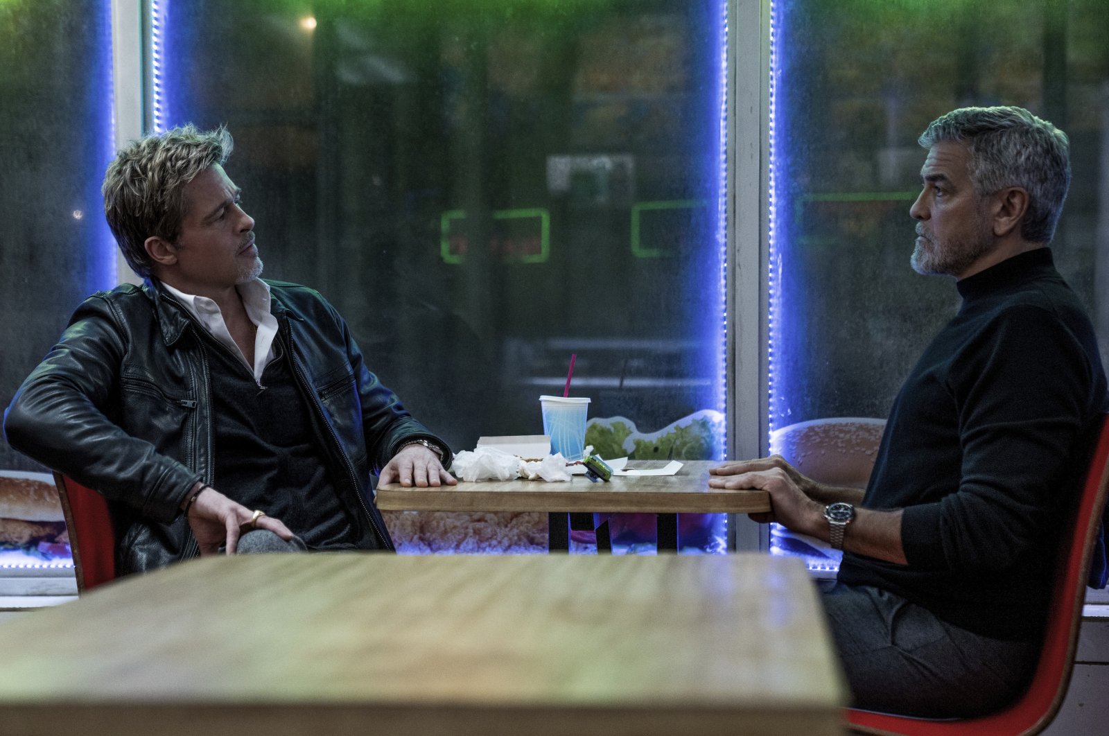 This image released by Apple TV  shows Brad Pitt (L) and George Clooney in a scene from &quot;Wolfs.&quot; (AP Photo)