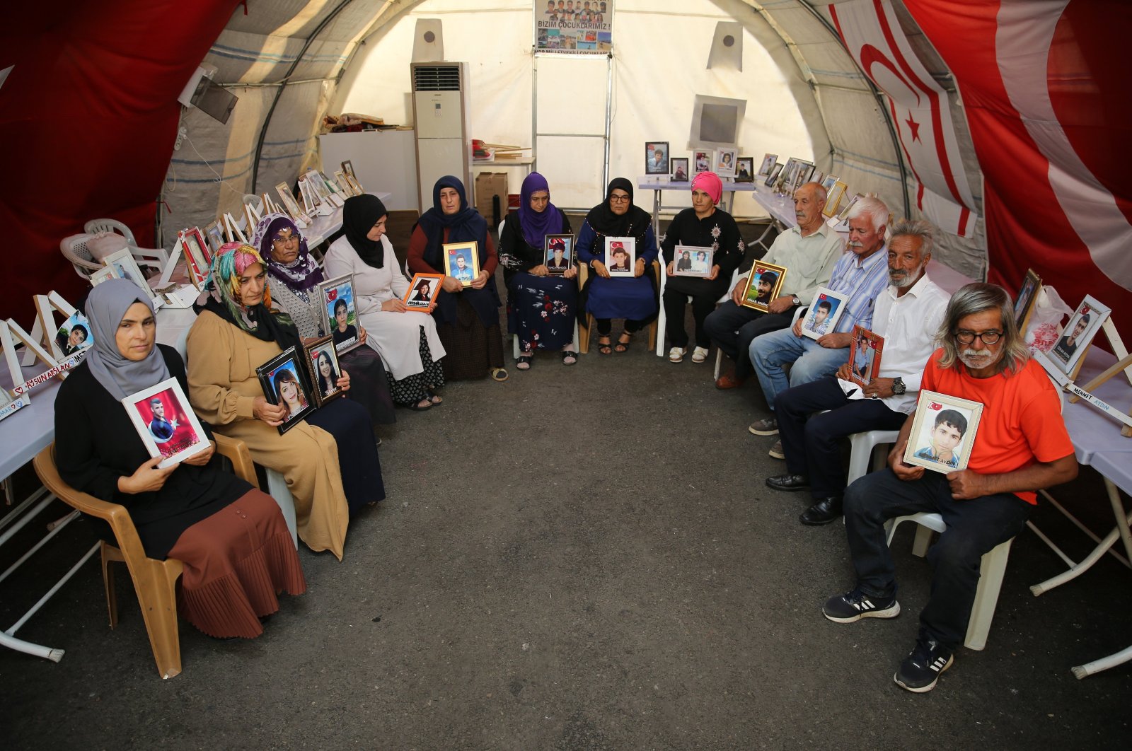 The &quot;Diyarbakır Mothers&quot; and male protesters accompanying them hold photos of their children kidnapped by the PKK, in Diyarbakır, southeastern Türkiye, Sept. 1, 2024. (AA Photo)