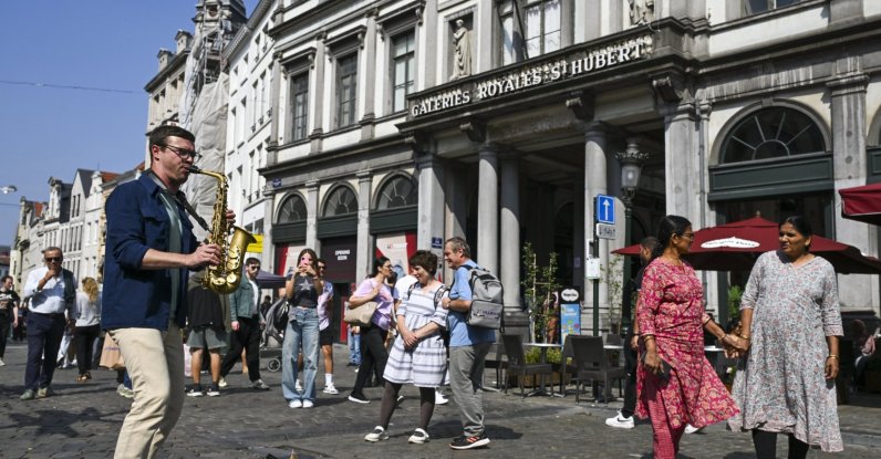 Tourists walk past a street performer as they visit the historic center around the Grand-Place square, Brussels, Belgium, Aug. 31, 2024. (EPA Photo)