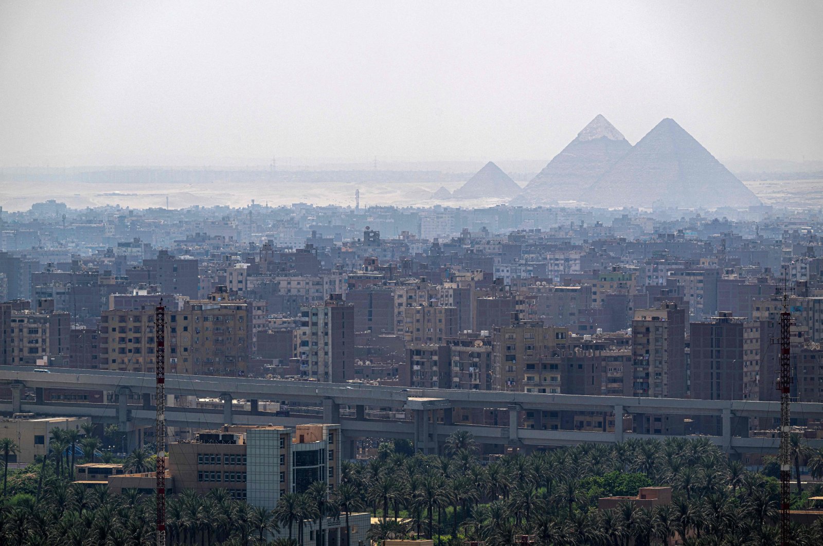 The pyramids appear behind the skyline of Cairo, Egypt, Aug. 25, 2024. (AFP Photo)