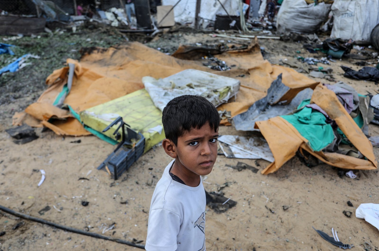 A Palestinian child stands in front of a tent destroyed in Israeli attack, Khan Younis, southern Gaza Strip, Palestine, Sept. 3, 2024.