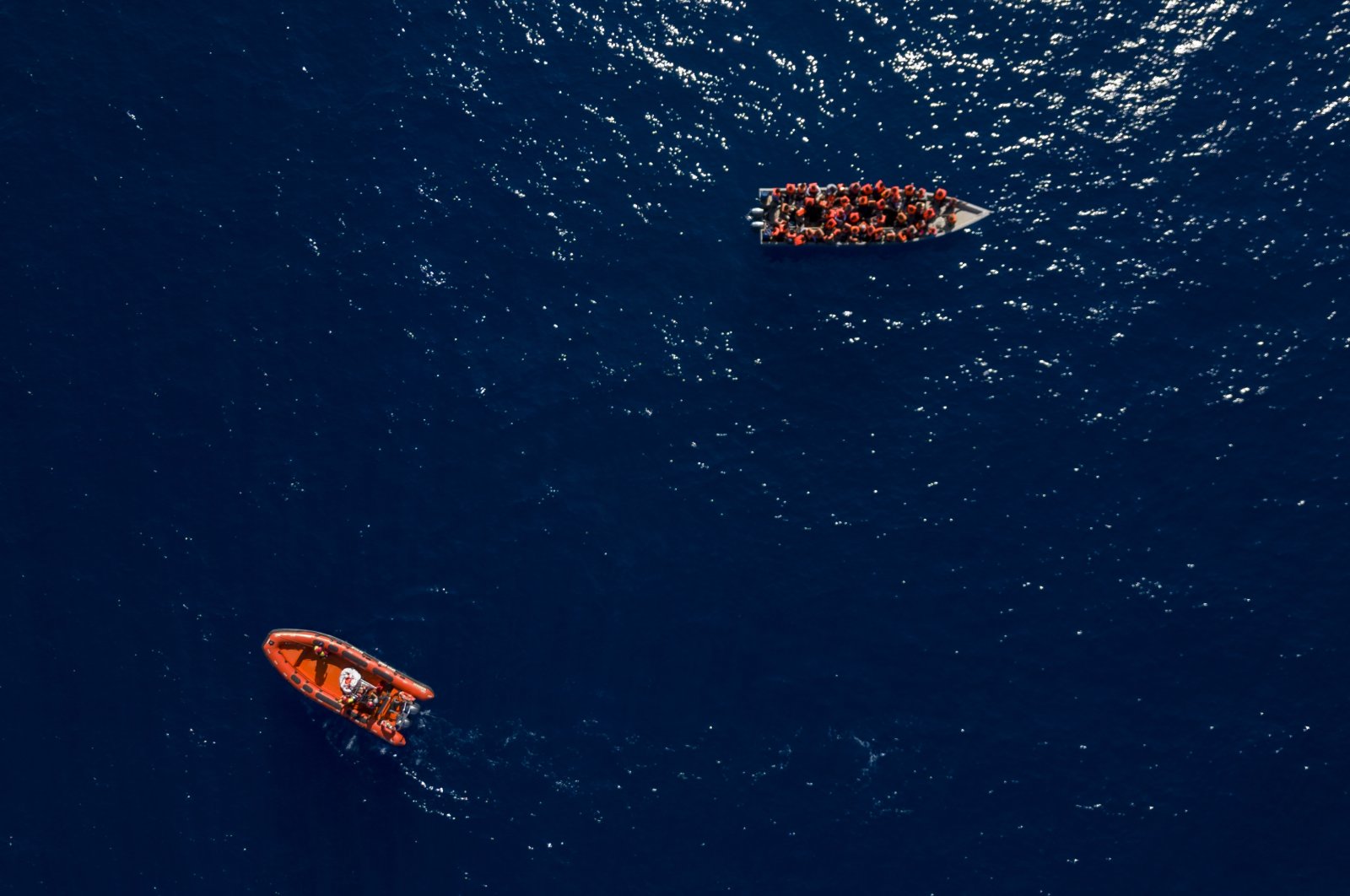 Migrants from Eritrea, Libya and Sudan sailing on a wooden boat, are assisted by aid workers of the Spanish NGO Open Arms, in the Mediterranean Sea, about 30 miles north of Libya, June 17, 2023. (AP File Photo)