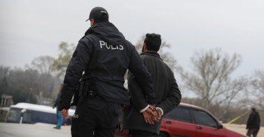 An irregular migrant is detained by a police officer near the Turkish-Greek border, in northwestern Edirne province, Türkiye, March 10, 2020. (AP Photo)