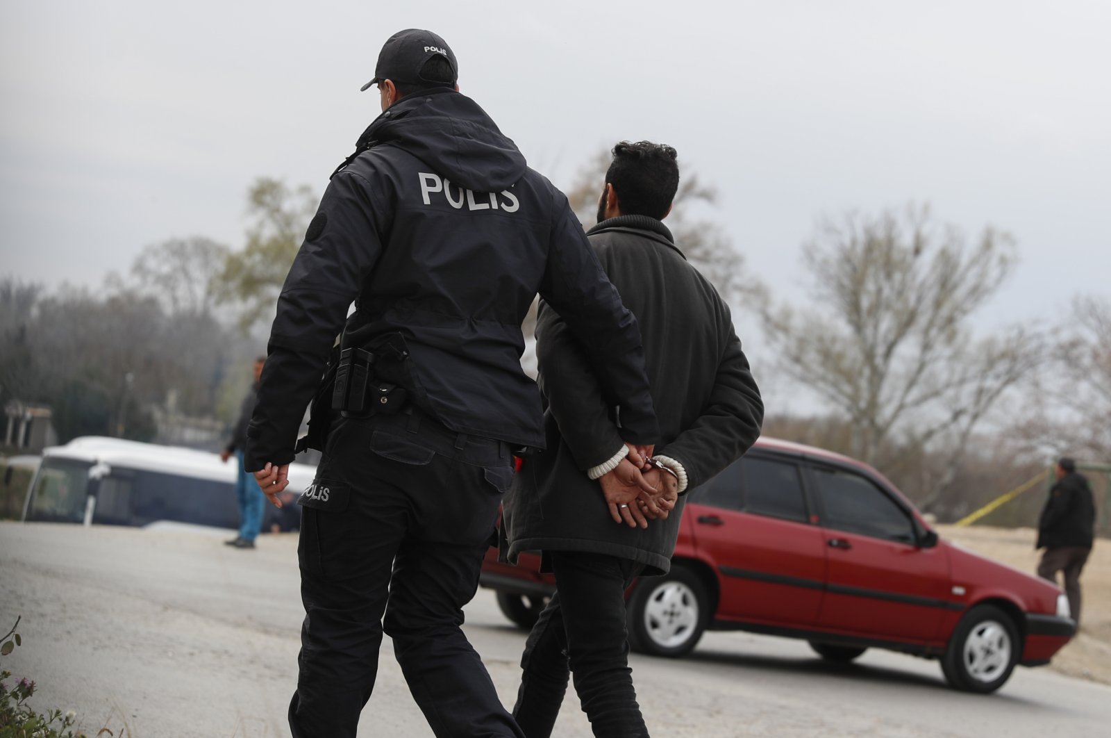 An irregular migrant is detained by a police officer near the Turkish-Greek border, in northwestern Edirne province, Türkiye, March 10, 2020. (AP Photo)