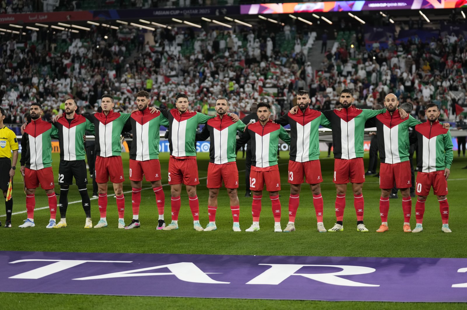 Palestine team players stand for the national anthem ahead of the Asian Cup Group C match between Iran and Palestine at the Education City Stadium, Al Rayyan, Qatar, Jan. 14, 2024. (AP Photo)