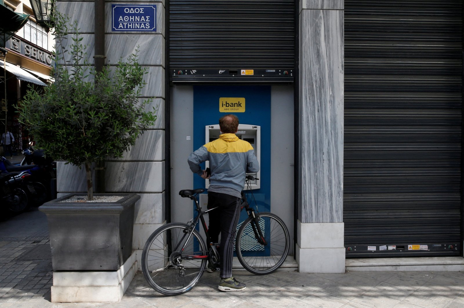 A man uses an ATM outside a National Bank branch in Athens, Greece, April 3, 2019. (Reuters Photo)