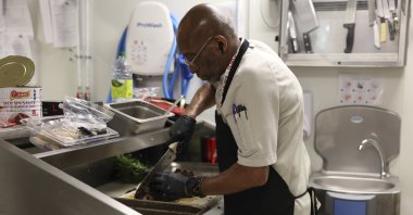 Kevin Oakes, cuts a rosemary pork loin with rosemary au jus in the kitchen of the United States Olympic and Paralympic Committee&#039;s High Performance Center during the Paralympic Games, Paris, France, Aug. 31, 2024. (AP Photo)