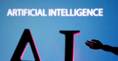 AI (Artificial Intelligence) letters and robot hand miniature in this illustration, taken June 23, 2023. (Reuters Photo)