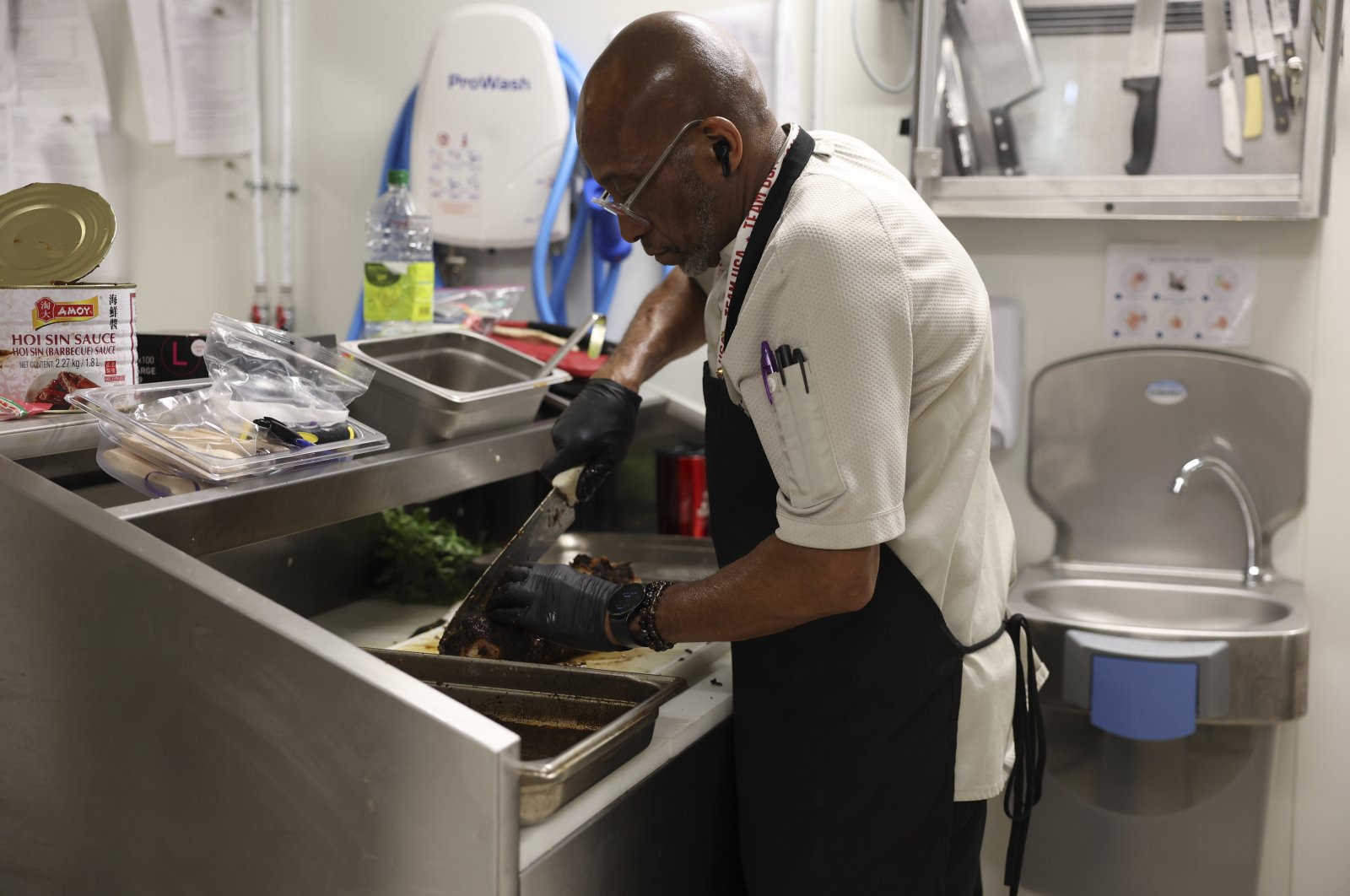 Kevin Oakes, cuts a rosemary pork loin with rosemary au jus in the kitchen of the United States Olympic and Paralympic Committee&#039;s High Performance Center during the Paralympic Games, Paris, France, Aug. 31, 2024. (AP Photo)