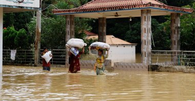 People carrying sacks wade through flood water amid severe flooding in the Fazilpur area of Feni, Bangladesh, Aug. 26, 2024. (Reuters Photo)