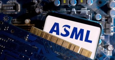 A smartphone with a displayed ASML logo is placed on a computer motherboard in this illustration taken on March 6, 2023. (Reuters Photo)