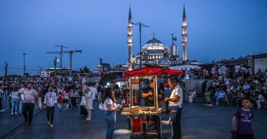A street vendor sells corn as he waits for customers in the popular Eminönü area of Istanbul, Türkiye, Aug. 30, 2024. (AFP Photo)