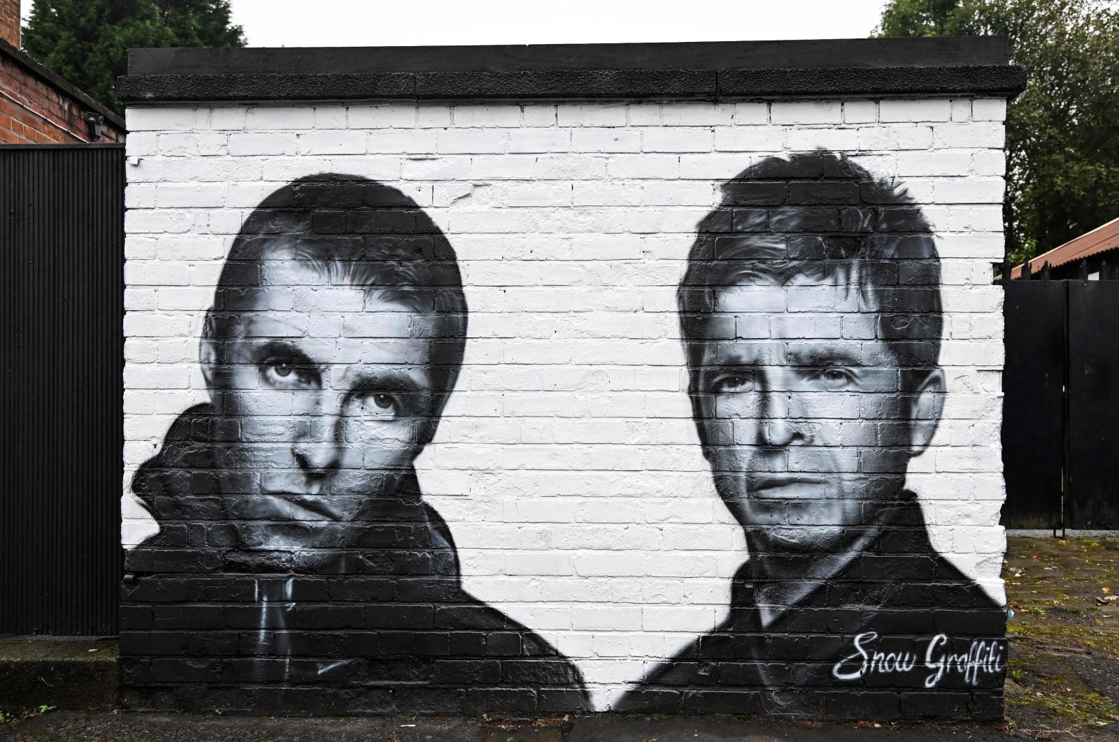 A mural created by artist Scott Wilcock, aka Snow Graffiti, depicts Liam Gallagher (L) and Noel Gallagher, members of the British rock band Oasis, outside the pub Whitefield, near Heaton Park, Manchester, northern Britain, Sept. 2, 2024. (AFP Photo)