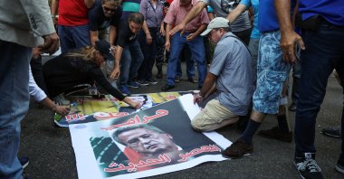 Demonstrators prepare to burn a picture of former Lebanese central bank chief Riad Salameh during a protest organized by Depositors' Outcry, a group campaigning for the rights of depositors in Lebanon, in support of his arrest, at the Justice Palace, Beirut, Lebanon, Sept. 5, 2024. (Reuters Photo)